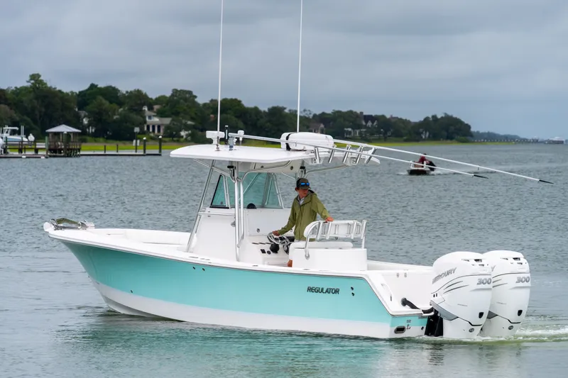 Slide: The Image of 2008 Regulator 29 Forward Seating boat cruising on a calm river with lush greenery. - 10