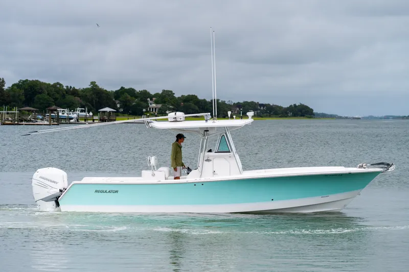 Slide: The Image of 2008 Regulator 29 Forward Seating boat cruising on a calm lake under cloudy skies. - 1