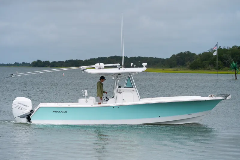 Slide: The Image of 2008 Regulator 29 Forward Seating boat on calm water, side view. - 2