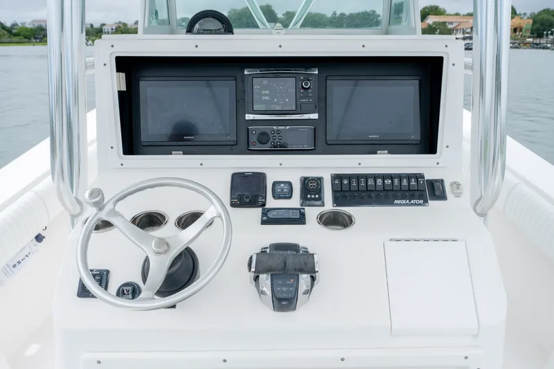 Slide: The Image of 2008 Regulator 29 Forward Seating boat dashboard with steering wheel and navigation controls. - 23