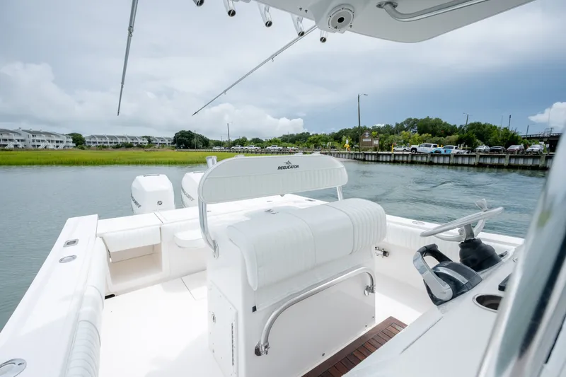 Slide: The Image of 2008 Regulator 29 Forward Seating boat on calm water, showcasing sleek design and dual engines. - 25