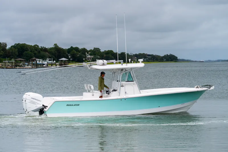 The Image of 2008 Regulator 29 Forward Seating boat on calm water, with a person at the helm. - 0