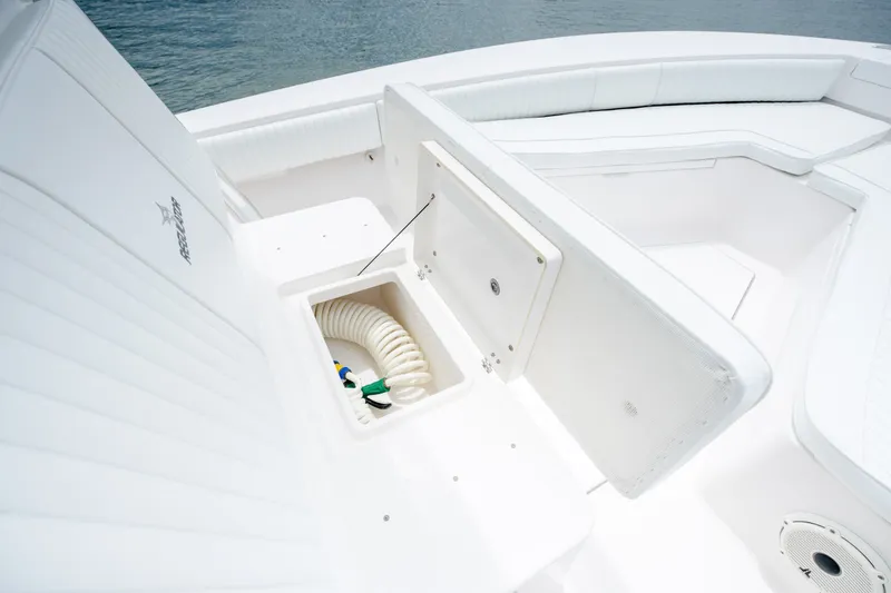 Slide: The Image of 2008 Regulator 29 Forward Seating boat with open storage compartment and coiled hose. - 32
