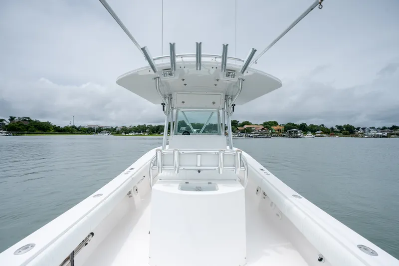 Slide: The Image of 2008 Regulator 29 Forward Seating boat on calm water, showcasing sleek design and spacious deck. - 18