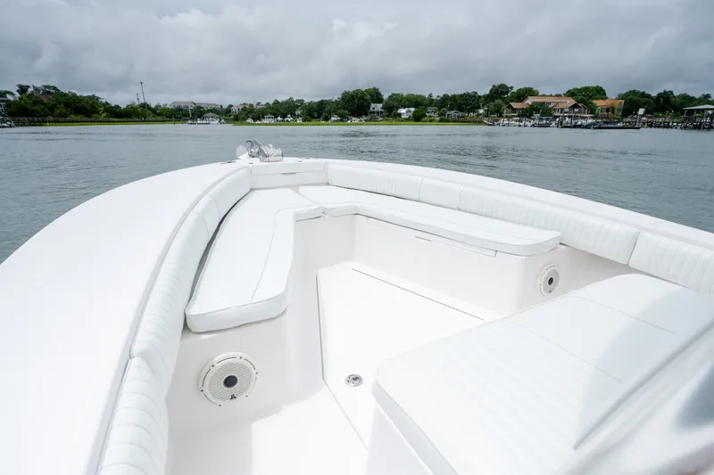 Slide: The Image of 2008 Regulator 29 Forward Seating boat on calm water, featuring spacious white seating. - 27