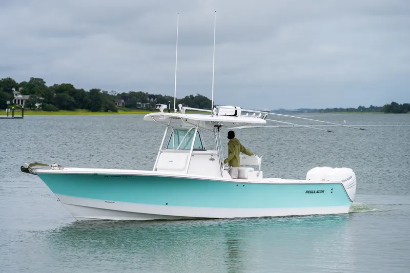 Slide: The Image of 2008 Regulator 29 Forward Seating boat cruising on a calm lake under cloudy skies. - 8