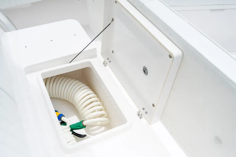 Slide: The Image of Storage compartment with coiled hose on a 2008 Regulator 29 Forward Seating boat. - 31