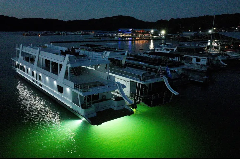 Slide: The Image of 1999 Stardust Cruisers 20 x 123 houseboat illuminated at night in a marina setting. - 8