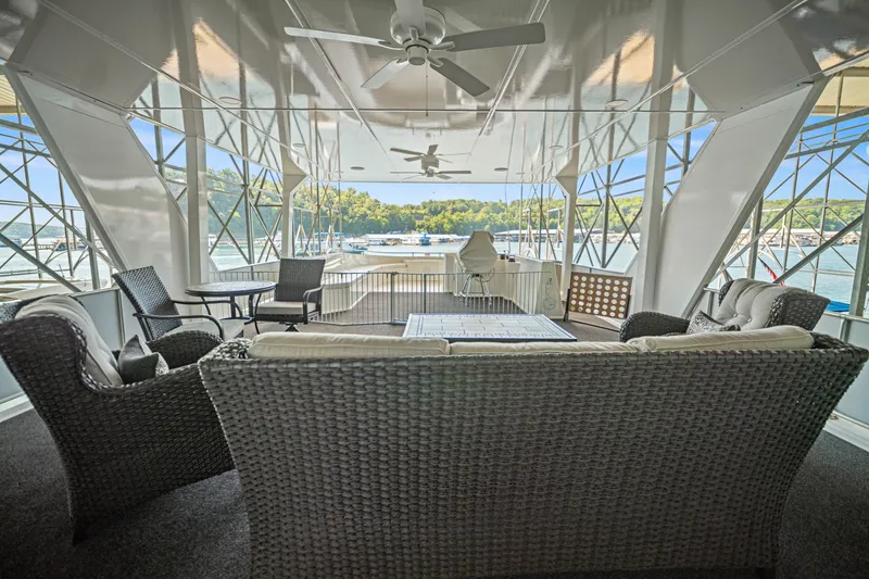 Slide: The Image of Luxurious 1999 Stardust Cruisers houseboat interior with wicker seating and scenic lake views. - 36