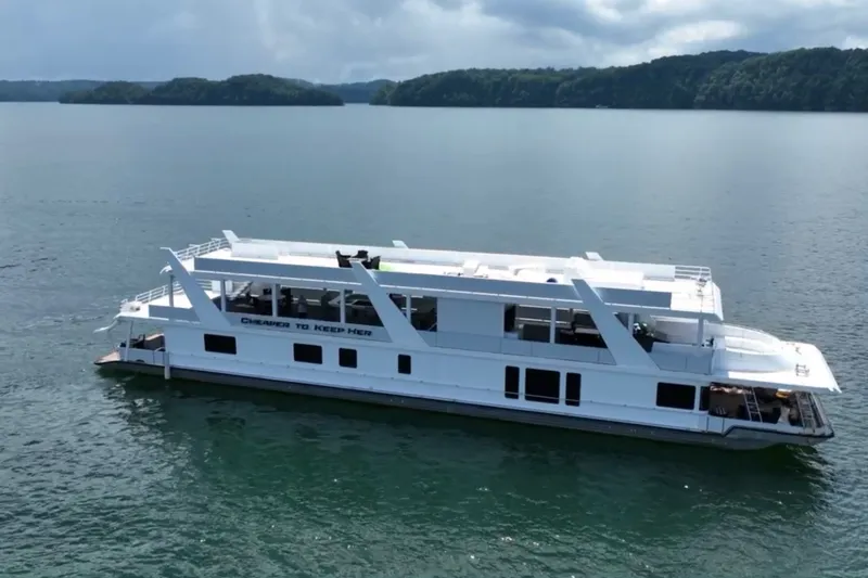 The Image of 1999 Stardust Cruisers 20 x 123 houseboat on a serene lake with lush green islands. - 1