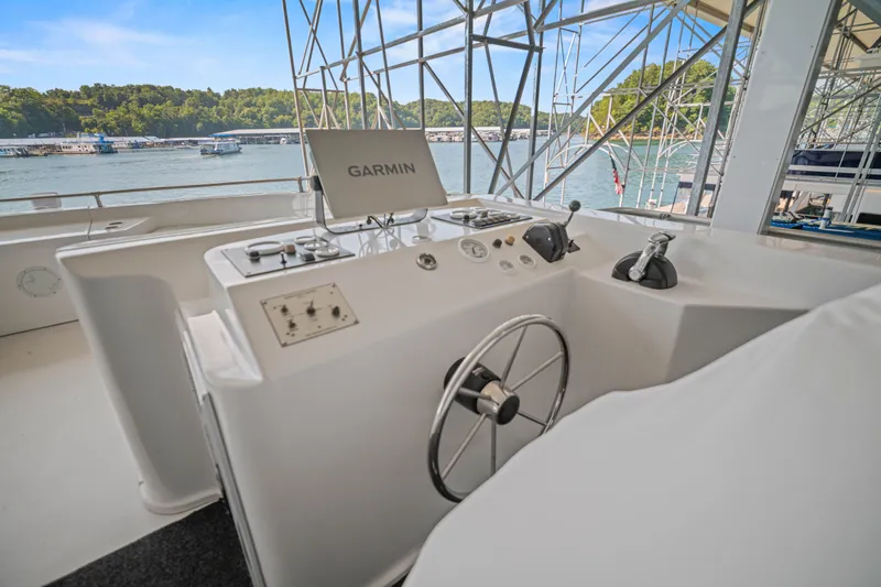 Slide: The Image of 1999 Stardust Cruisers 20 x 123 boat helm with Garmin navigation, docked by scenic lake. - 33