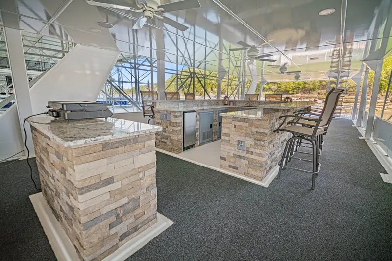 Slide: The Image of Luxurious 1999 Stardust Cruisers houseboat with outdoor bar, stone countertops, and seating area. - 32
