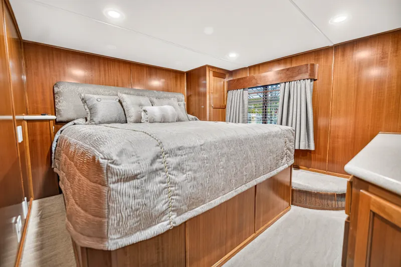 Slide: The Image of Luxurious bedroom interior of 1999 Stardust Cruisers houseboat with wood paneling and plush bedding. - 17