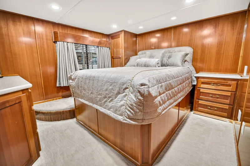 Slide: The Image of Luxurious bedroom interior of 1999 Stardust Cruisers houseboat with wood paneling and plush bedding. - 23