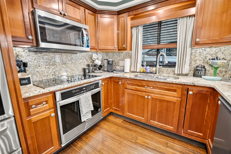 Slide: The Image of Luxurious kitchen in 1999 Stardust Cruisers houseboat with granite countertops and wooden cabinetry. - 15