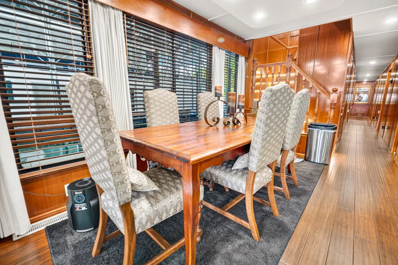 Slide: The Image of Luxurious dining area inside a 1999 Stardust Cruisers 20 x 123 houseboat, featuring elegant wooden furniture. - 12