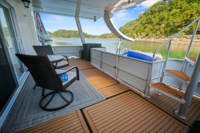 Slide: The Image of 1999 Stardust Cruisers 20 x 123 houseboat deck with chairs, table, and scenic lake view. - 37