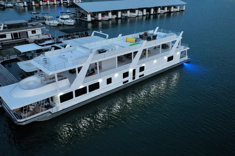 Slide: The Image of Large 1999 Stardust Cruisers houseboat docked at marina, illuminated at dusk. - 7