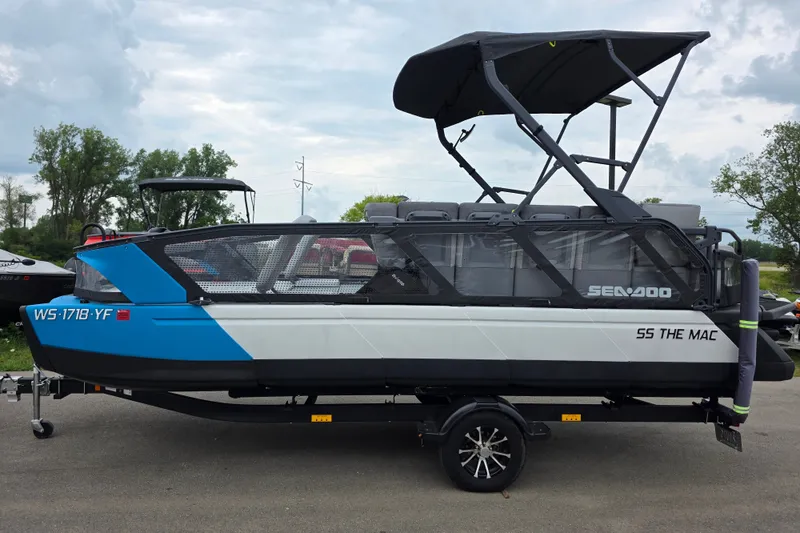 Slide: The Image of 2023 Sea-Doo Switch Sport 21 pontoon boat on trailer, parked outdoors. - 1