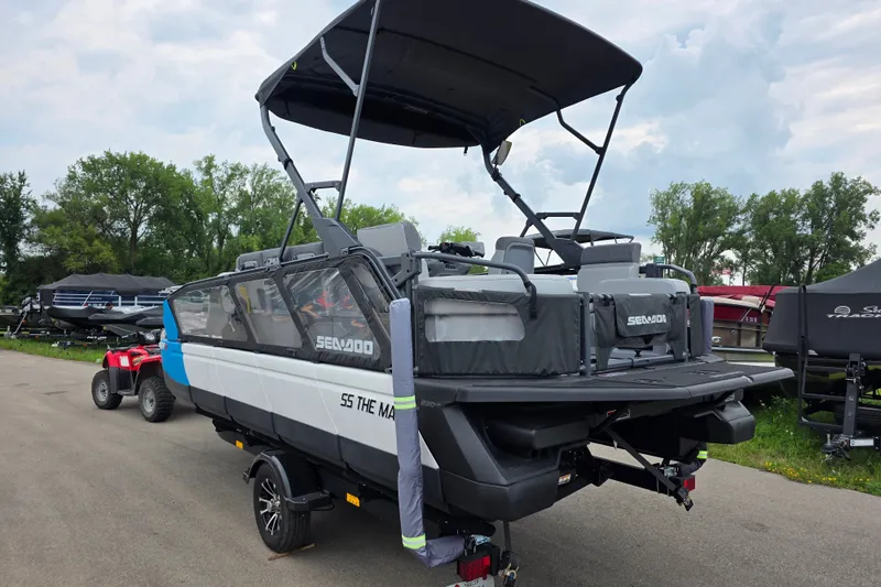 Slide: The Image of 2023 Sea-Doo Switch Sport 21 pontoon boat on trailer, parked outdoors. - 2