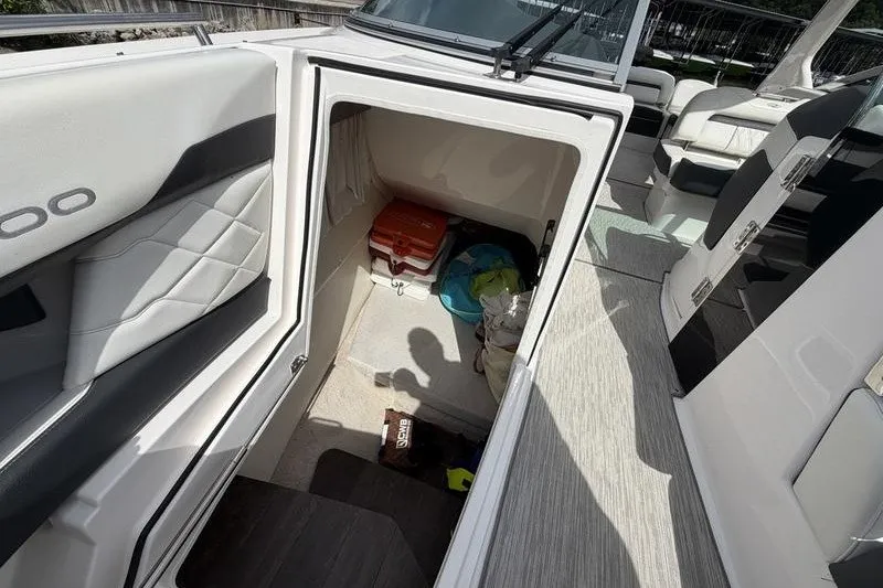 Slide: The Image of 2019 Regal 3300 Bowrider storage compartment with various items inside. - 16