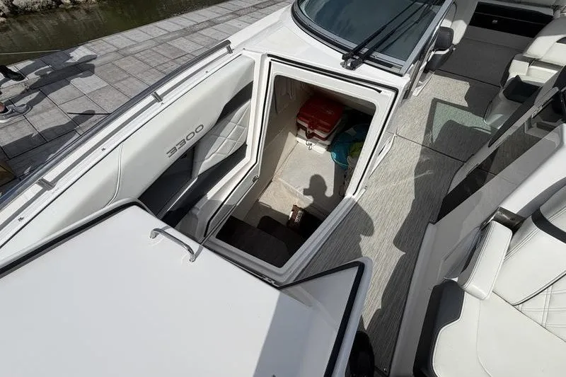 Slide: The Image of 2019 Regal 3300 Bowrider boat interior with open storage compartment. - 15