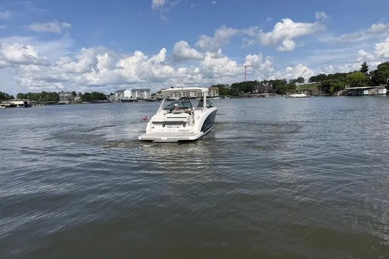 Slide: The Image of 2019 Regal 3300 Bowrider cruising on a scenic lake under a partly cloudy sky. - 6