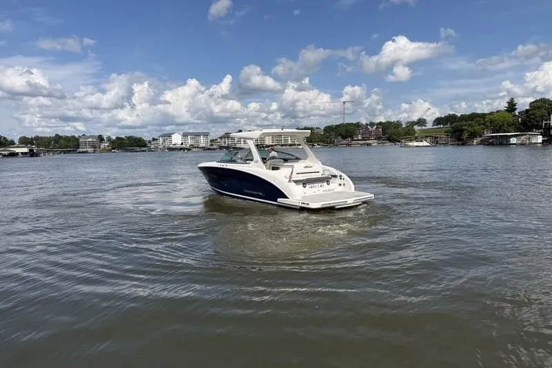 Slide: The Image of 2019 Regal 3300 Bowrider cruising on a scenic lake under a partly cloudy sky. - 8