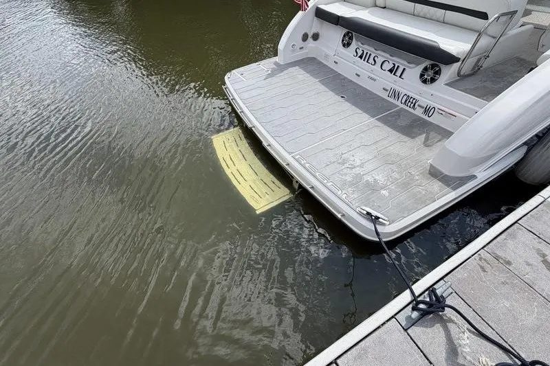 Slide: The Image of 2019 Regal 3300 Bowrider docked, rear view with swim platform, "Sails Call" name visible. - 24