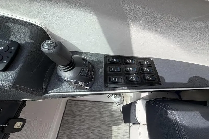 Slide: The Image of Control panel of a 2019 Regal 3300 Bowrider boat with joystick and switches. - 13