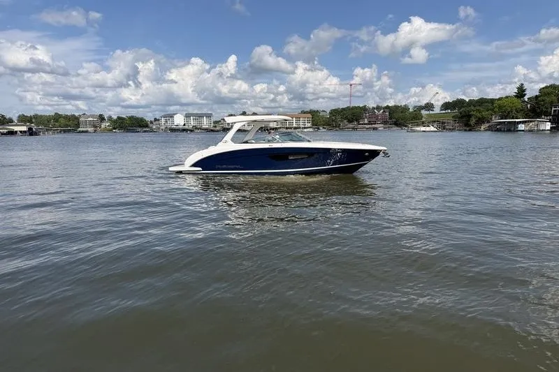 The Image of 2019 Regal 3300 Bowrider on calm water under a partly cloudy sky. - 1