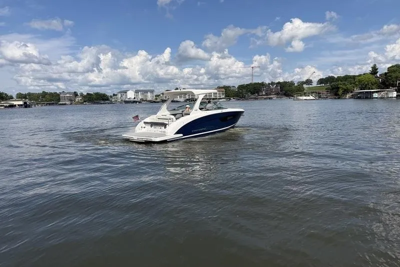 Slide: The Image of 2019 Regal 3300 Bowrider cruising on a scenic lake under a partly cloudy sky. - 5