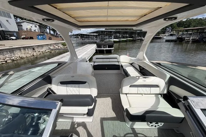 Slide: The Image of 2019 Regal 3300 Bowrider interior with spacious seating, docked at a marina. - 11
