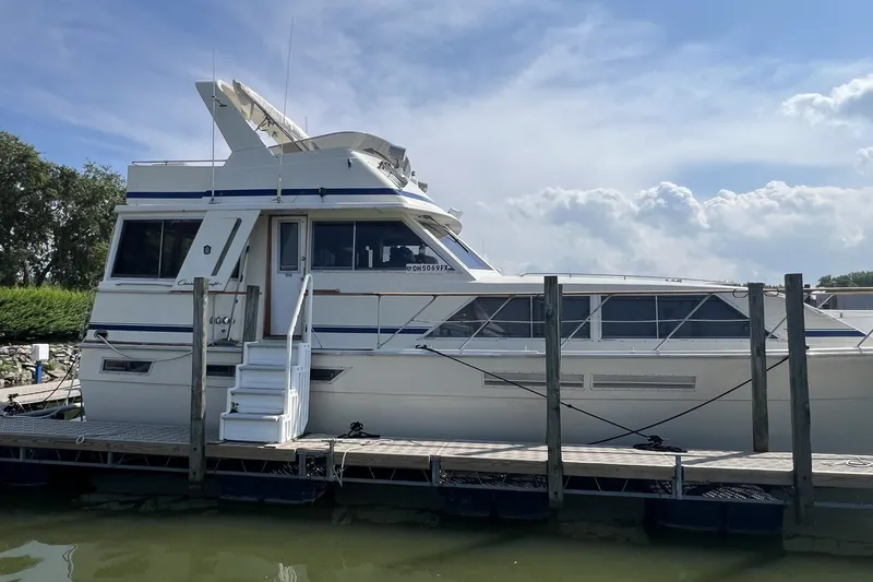 The Image of 1986 Chris Craft 47 Constellation yacht docked under a clear blue sky. - 1