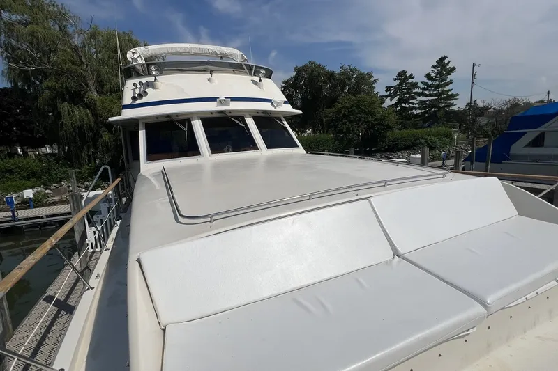 Slide: The Image of 1986 Chris Craft 47 Constellation yacht docked, showcasing sleek design and spacious deck. - 14