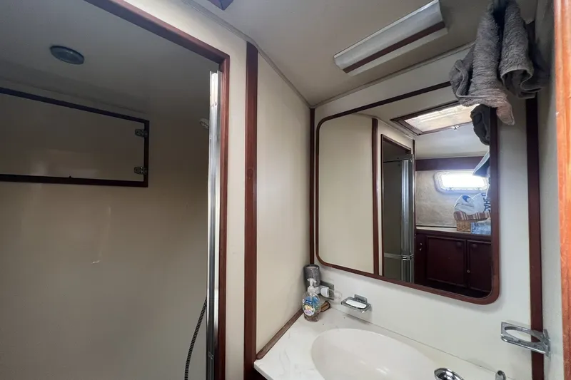 Slide: The Image of 1986 Chris Craft 47 Constellation yacht bathroom with mirror, sink, and shower area. - 62