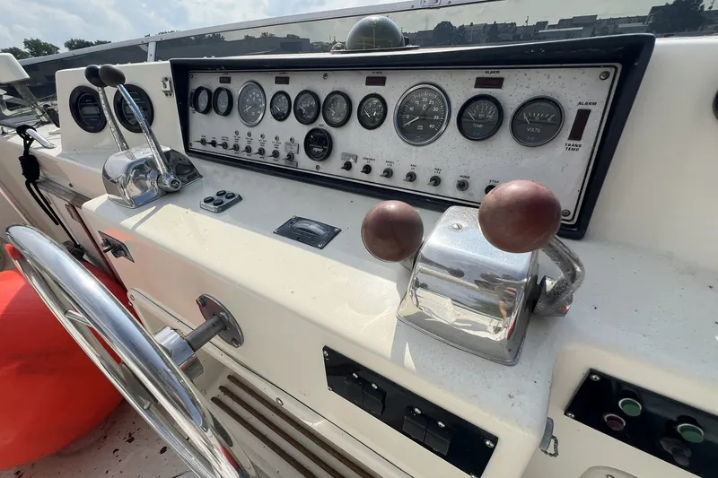 Slide: The Image of 1986 Chris Craft 47 Constellation helm with gauges, controls, and steering wheel. - 91