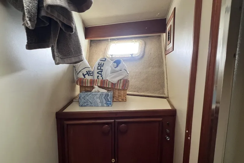 Slide: The Image of Interior of 1986 Chris Craft 47 Constellation with towels and cabinet under a small window. - 60