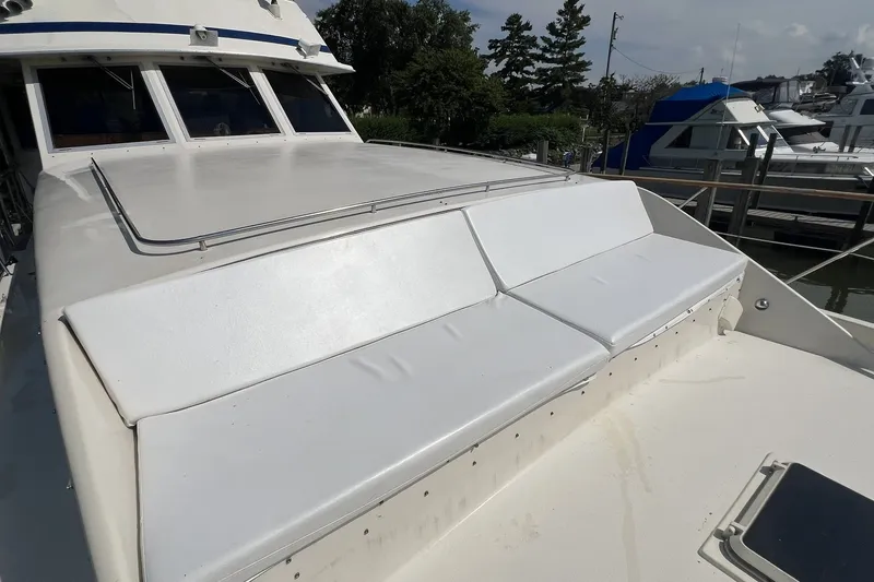 Slide: The Image of 1986 Chris Craft 47 Constellation yacht with white deck seating, docked at marina. - 13