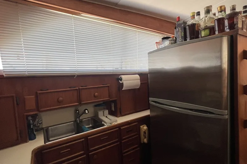 Slide: The Image of Kitchen area of a 1986 Chris Craft 47 Constellation yacht with stainless steel fridge. - 31