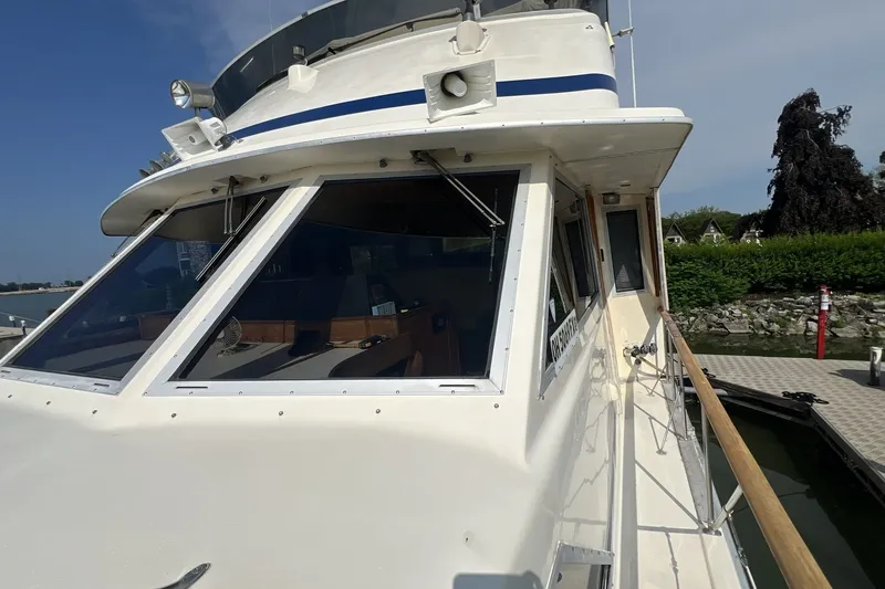 Slide: The Image of 1986 Chris Craft 47 Constellation yacht docked, showcasing its sleek design and spacious deck. - 112