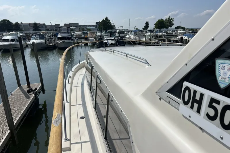 Slide: The Image of 1986 Chris Craft 47 Constellation yacht docked at a marina with other boats. - 110