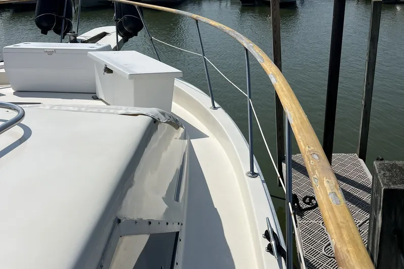 Slide: The Image of 1986 Chris Craft 47 Constellation yacht deck with wooden railing and storage boxes. - 11