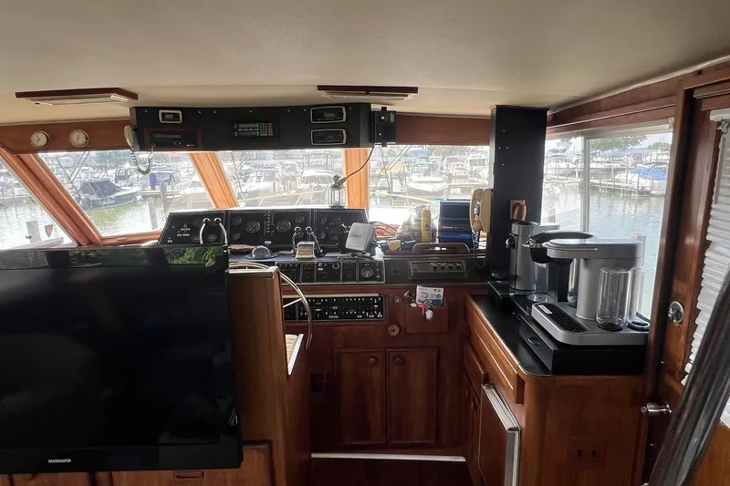 Slide: The Image of Interior of 1986 Chris Craft 47 Constellation yacht with helm, appliances, and marina view. - 27