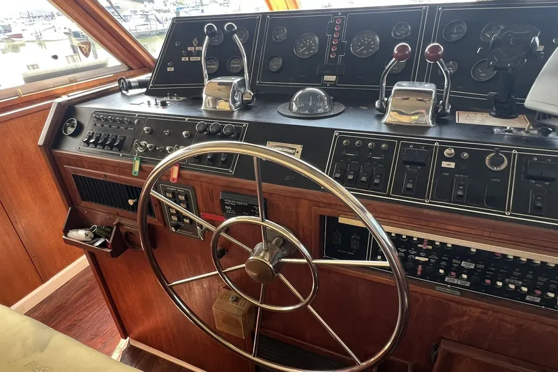 Slide: The Image of Control panel of a 1986 Chris Craft 47 Constellation yacht with steering wheel and gauges. - 78