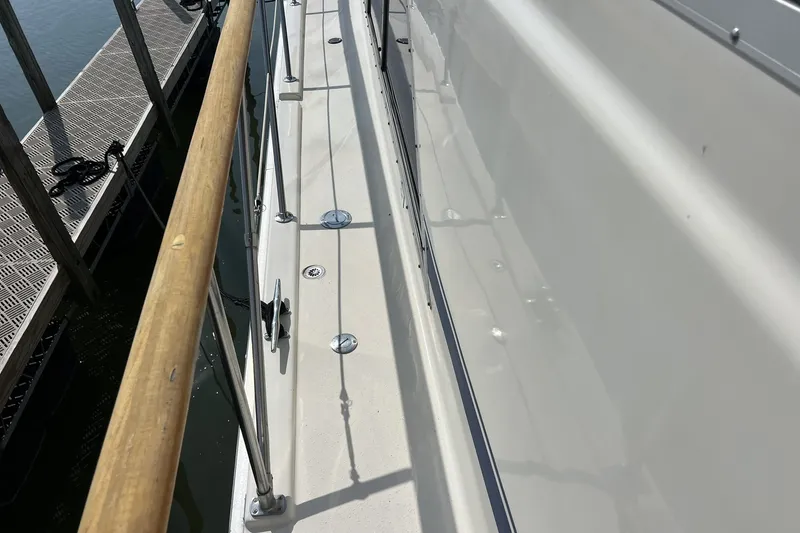 Slide: The Image of 1986 Chris Craft 47 Constellation yacht deck with wooden railing and dock view. - 109