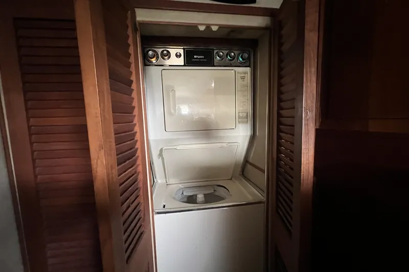 Slide: The Image of Laundry area inside 1986 Chris Craft 47 Constellation yacht with wooden louvered doors. - 72