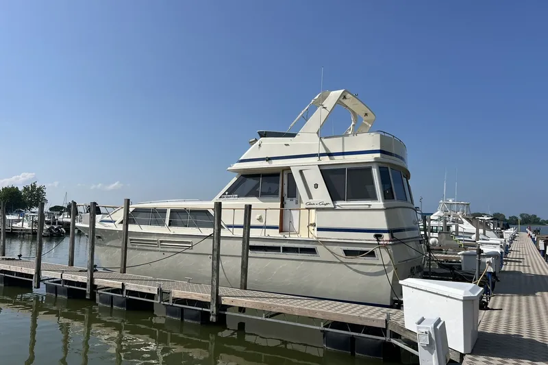 Slide: The Image of 1986 Chris Craft 47 Constellation yacht docked at a marina under clear blue skies. - 117