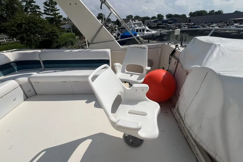 Slide: The Image of 1986 Chris Craft 47 Constellation yacht deck with white seating and marina view. - 86