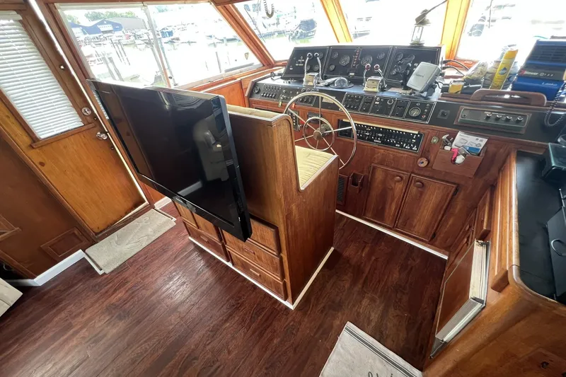 Slide: The Image of 1986 Chris Craft 47 Constellation yacht interior with wooden helm and modern TV. - 82